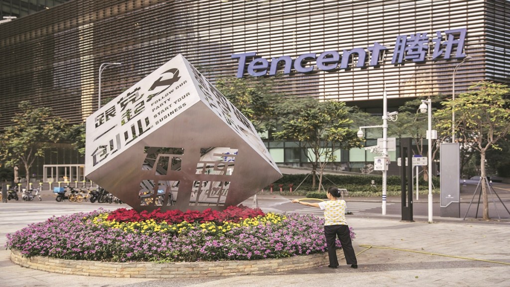 A worker waters the flowers around an installation reading "Follow Our Party Start Your Business" in front of the Tencent Holdings Ltd. headquarters in Shenzhen, China, on Saturday, March 20, 2021. Asia’s largest conglomerate was censured by China’s antitrust watchdog on Friday as Beijing expands a crackdown that began with Jack Ma’s online empire. Photographer: Qilai Shen/Bloomberg
