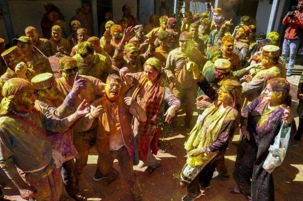People daubed in colours sing Holi songs going door to door during Holi celebrations in Kullu. (PTI photo)