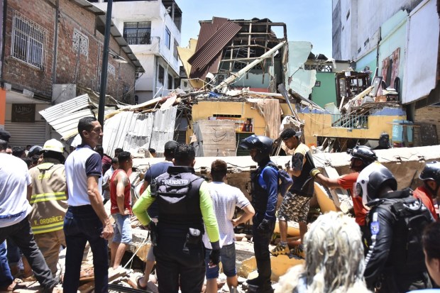 Residents and rescue workers stand in front of buildings brought down by an earthquake. (AP Photo)