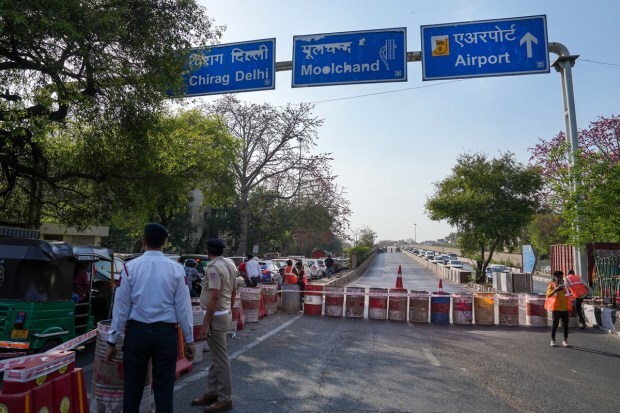 Public Works Department (PWD) workers close a road before repairing the Chirag Delhi flyover on the outer ring road. (PTI photo)