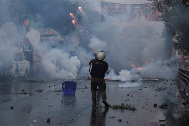 A police officer fires a tear gas shell to disperse the supporters of former Pakistan PM. (Reuters photo)