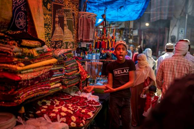 A young Muslim vendor, left, sells flowers to devotees visiting Nizamuddin Dargah, the burial site of revered Sufi saint Nizamuddin Auliya, ahead of the Islamic holy month of Ramadan in New Delhi, India. (AP Photo)