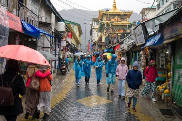 People walk in the rain in Dharamshala, India (AP Photo)
