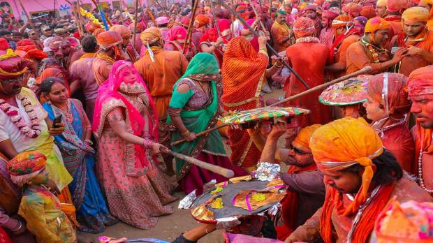  Nandgaon women beat men from Barsana with sticks during traditional 'Lathmar Holi', in Nandgaon, Wednesday, March 1, 2023. (PTI Photo)
