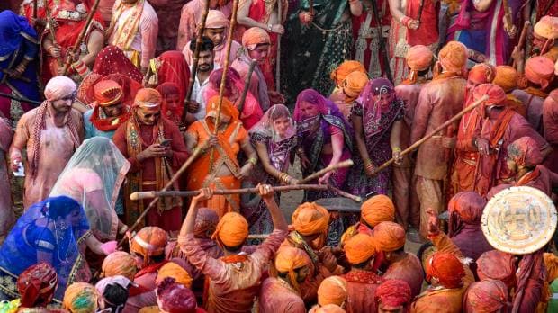 Nandgaon women beat men from Barsana with sticks during traditional 'Lathmar Holi', in Nandgaon, Wednesday, March 1, 2023. (PTI Photo)