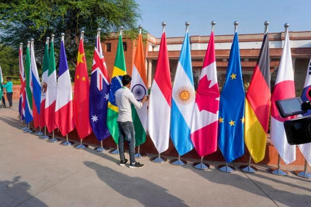 New Delhi: A worker arranges flags of participating countries, put up for the G20 Foreign Ministers' Meeting, at RBCC in New Delhi, Thursday, March 2, 2023. (PTI Image)