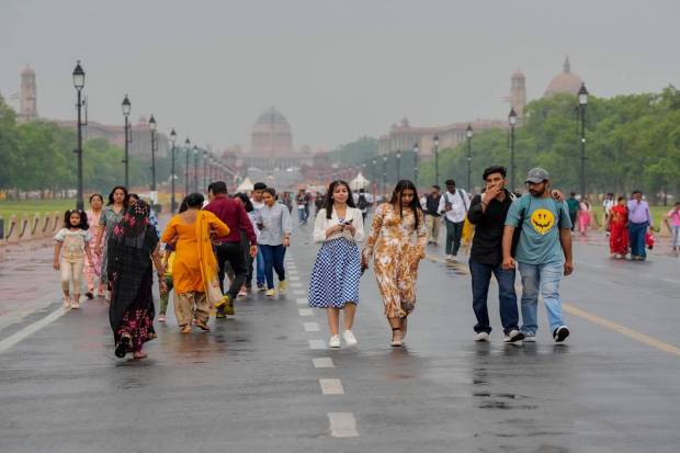 New Delhi: People walk amid rains on the Kartavya Path near India Gate, in New Delhi. (PTI Photo)