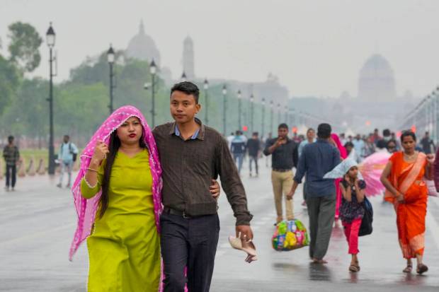 New Delhi: People walk on Kartavya Path amid rainfall, near India Gate in New Delhi. (PTI Photo)