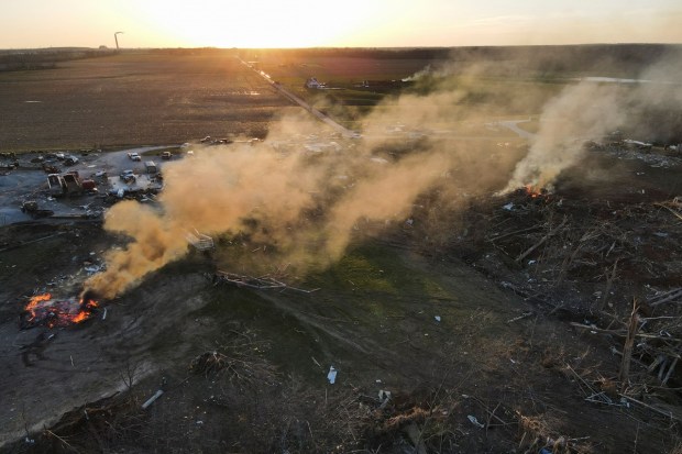 Plumes of smoke from burning piles of wood cleared by work crews rise at the site of severe storm damage in the aftermath of a tornado in Sullivan, Indiana. (Reuters photo)