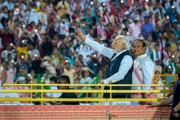 Prime Minister Narendra Modi, leftt, and Assam chief minister Himanta Biswa Sarma wave towards the waiting Assamese dancers and musicians ahead of their performance to attempt Guinness World Record in the largest folk dance performance category in Guwahati, India. Around 11,000 Bihu dancers and musicians performed together to set a new record for Guinness World Record in the largest folk dance performance category. (AP Photo)