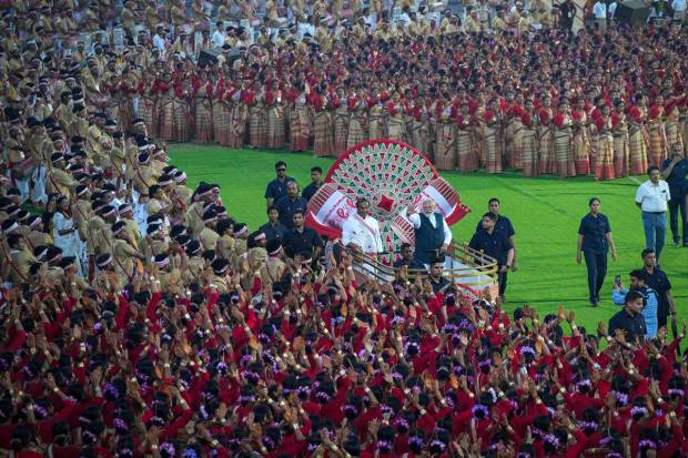 Prime Minister Narendra Modi, right, wave towards the waiting Assamese dancers and musicians ahead of their performance to attempt Guinness World Record in the largest folk dance performance category in Guwahati, India. (AP Photo)