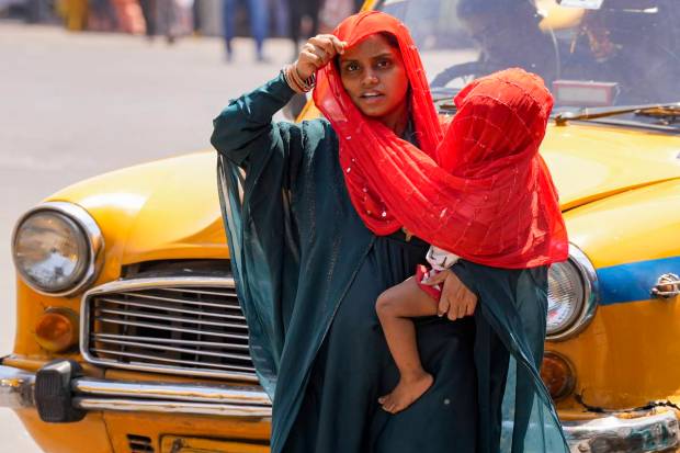 A woman tries to protect her child from scorching sun during a hot summer day, in Kolkata.(PTI)