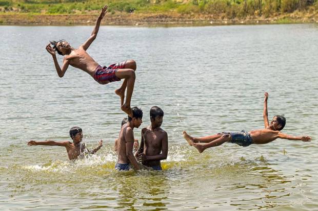 Nadia: Children take a bath to cool off in a pond on a hot summer day, in Nadia. (PTI)