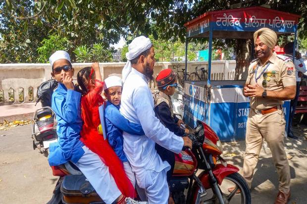 Patiala: A muslim with chidren rides his bike, during Eid celebrations, in Patiala. (PTI Photo)