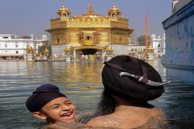 A holy dip in the sacred pond of the Golden Temple on the occasion of 'Baisakhi' festival, in Amritsar. (Photo: PTI)
