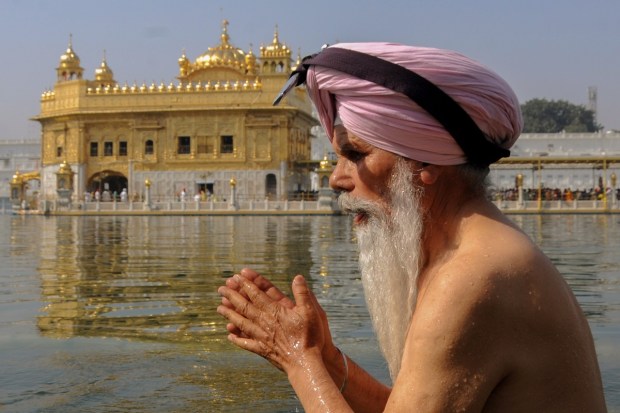 A devotee takes holy dip in the sacred pond of the Golden Temple on the occasion of 'Baisakhi' festival, in Amritsar. (Photo: PTI)