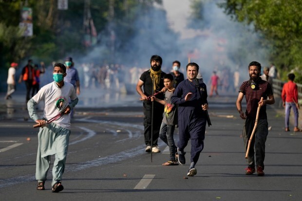 As the news of Khan's arrest spread, massive protests broke out in several cities across Pakistan. Supporters of Pakistan's former Prime Minister Imran Khan throws stones after police fire tear gas to disperse them protesting against the arrest of their leader in Lahore. (AP Photo)