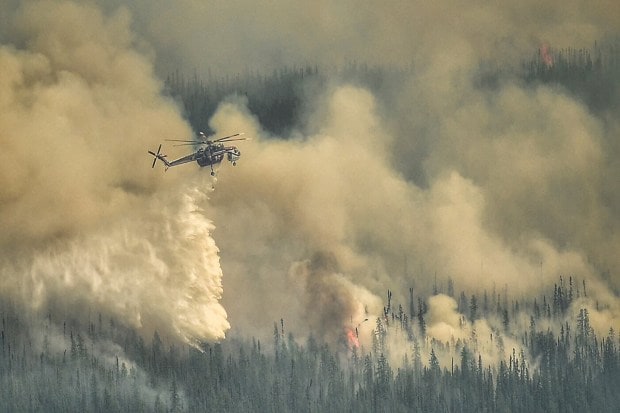 A Sky crane helicopter dumps water on the Eagle Wildfire Complex near Fox Creek, Alberta, Canada (Reuters)