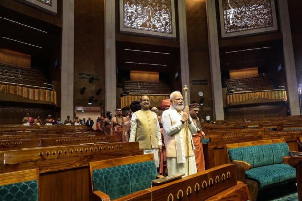 Prime Minister Narendra Modi carries the 'Sengol' in a procession before installing it in the Lok Sabha chamber at the inauguration of the new Parliament building. (Image/PTI)