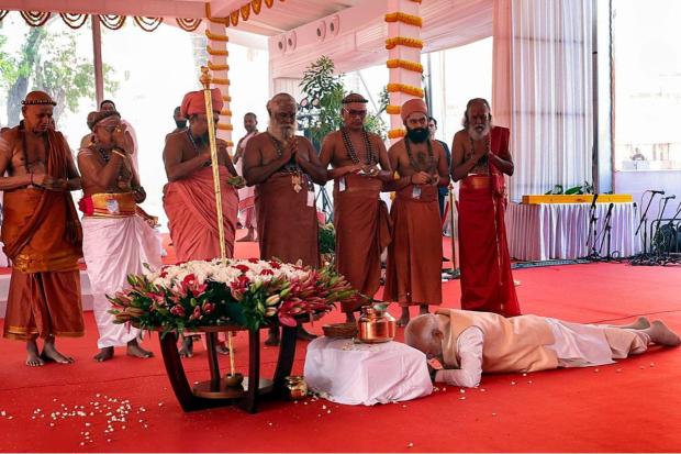 Prime Minister Narendra Modi prostrates before the 'Sengol' at the inauguration of the new Parliament building. (Image/PTI)