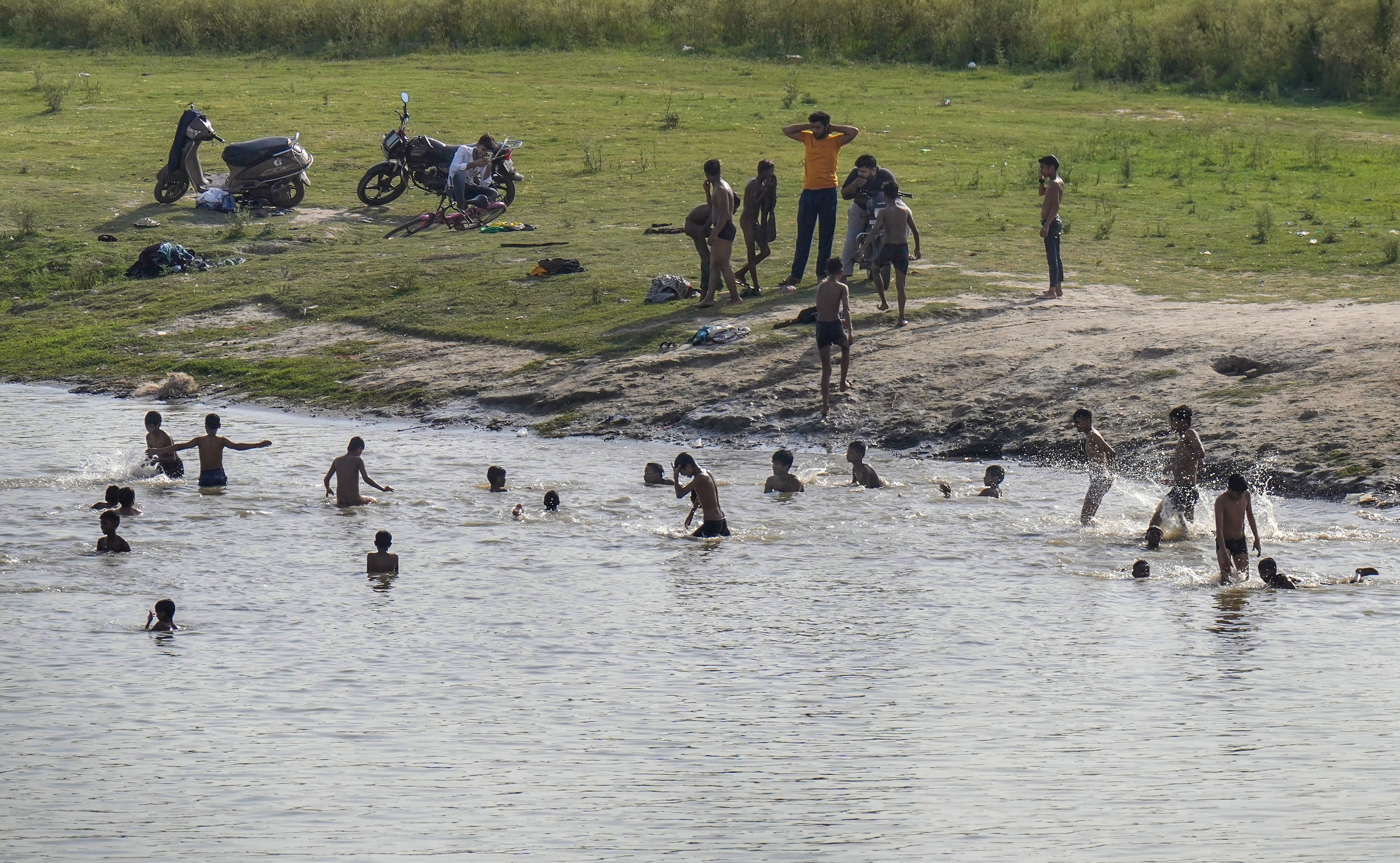 Children bathe in a pond to cool themselves during a hot summer day, in New Delhi. (PTI photo)