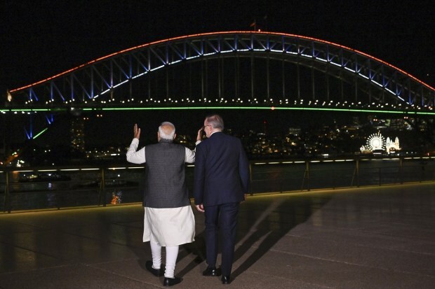 Prime Minister Narendra Modi and Australian Prime Minister Anthony Albanese are photographed in front of the Sydney Harbour Bridge illuminated in the colors of the Indian flag in Sydney. (Image/PTI)