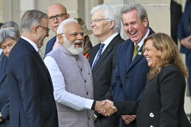 PM Modi reacts as he shakes hands with officials as Australia's Prime Minister Anthony Albanese, (left), watches during a ceremonial welcome at Admiralty House. Modi is the only leader of the so-called Quad nations to continue with his scheduled visit to Australia after U.S. President Joe Biden pulled out of a planned meeting of the group in Sydney to return to Washington to focus on debt limit talks. (Image/AP)