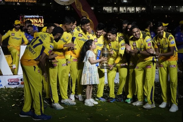 Players of Chennai Super Kings are joined by captain MS Dhoni's daughter as they celebrate with the winners trophy after their win in the IPL final cricket match against Gujarat Titans on May 30, 2023. (Image: AP)