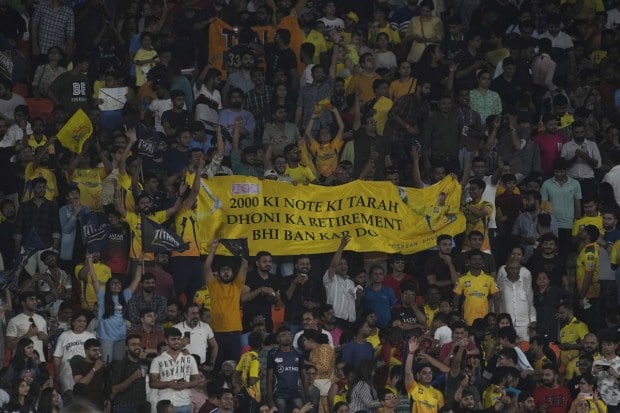Fans of Chennai Super Kings' captain MS Dhoni display a banner during the Indian Premier League final cricket match between Chennai Super Kings and Gujarat Titans. (Image: AP)