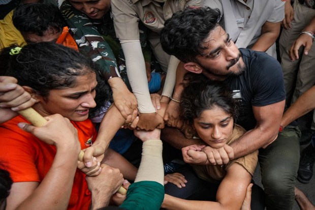Security personnel detain wrestlers Vinesh Phogat and Sangeeta Phogat during wrestlers' protest march towards the new Parliament building in New Delhi on Sunday. (Photo: PTI)
