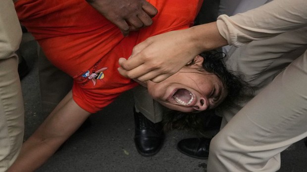 Security personnel detain wrestler Sangeeta Phogat during wrestlers' protest march towards new Parliament building in New Delhi on Sunday. (Photo: PTI)