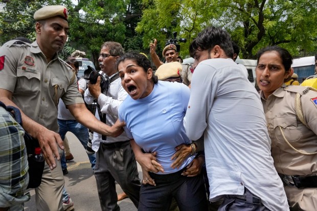 Security personnel detain wrestler Sakshi Malik during wrestlers' protest march towards the new Parliament building, in New Delhi, Sunday. (Photo: PTI)