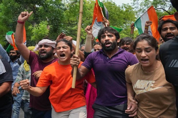 Wrestlers Vinesh Phogat, Sangeeta Phogat and Bajrang Punia with supporters during their protest march towards the new Parliament building, in New Delhi, Sunday. (Photo: PTI)