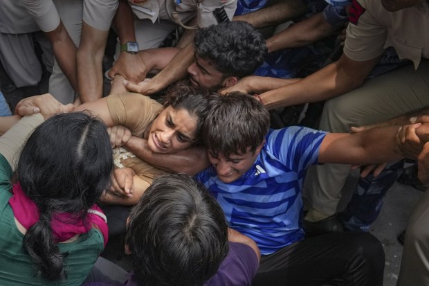 Security personnel detain wrestler Vinesh Phogat during wrestlers' protest march towards the new Parliament building, in New Delhi, Sunday. (Photo: PTI)