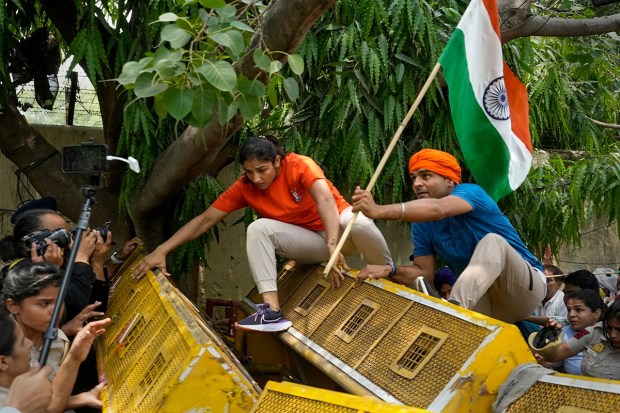 Wrestler Sangeeta Phogat crosses a police barricade during wrestlers' protest march towards the new Parliament building, in New Delhi, Sunday. (Photo: PTI)