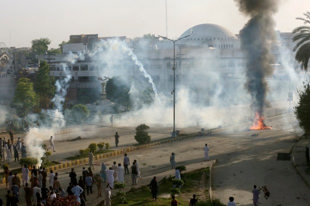 Police fire tear gas to disperse supporters of Imran Khan after a dramatic escalation of political tensions sparked violent demonstrations by his supporters in major cities. (AP Photo)