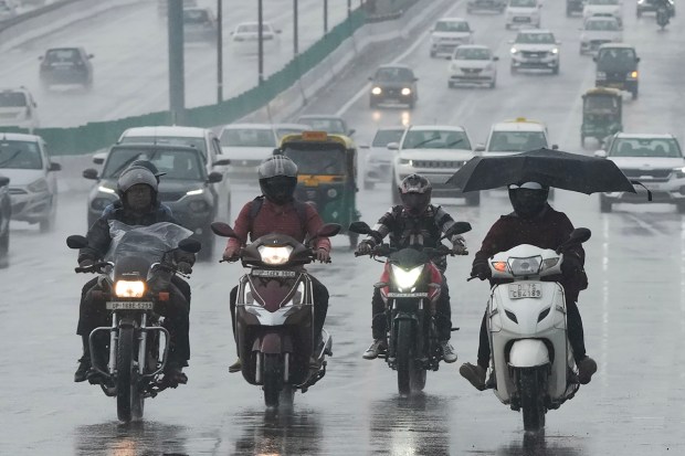 Commuters during Monsoon rainfall in New Delhi. (Image: PTI)