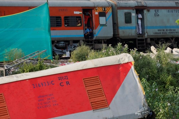 People look at damaged coaches from a train, after the tracks were restored. (Reuters Photo)