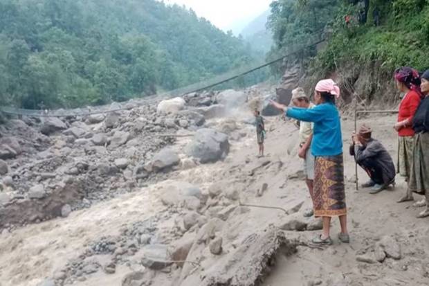 People stand near a site of a landslide caused due to heavy rains in Sankhuwasabha, Nepal. REUTERS