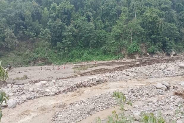 People walk near a site of a landslide caused due to heavy rains in Sankhuwasabha, Nepal. REUTERS