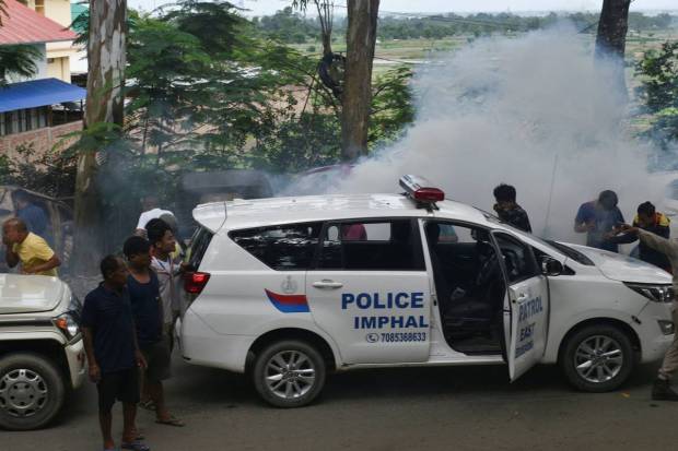 Locals cover their faces as police use tear gas to disperse the crowd gathered in support of Rahul Gandhi, a senior leader of India's main opposition Congress party, after his convoy heading to Churachandpur was stopped by the police in Bishnupur, northeastern state of Manipur, India. REUTERS