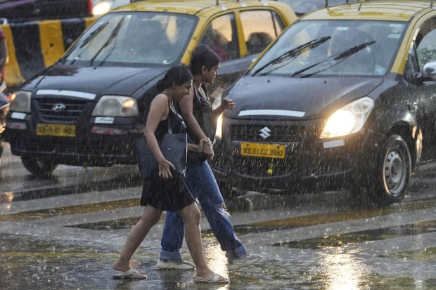 Due to rain, Maharashtra's capital witnessed waterlogging in several areas. People walk in the rain in Mumbai. (AP Photo)