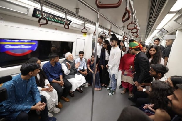 PM Modi on the way to the DU programme by the Delhi Metro. Happy to have youngsters as my co-passengers. (PTI Photo)