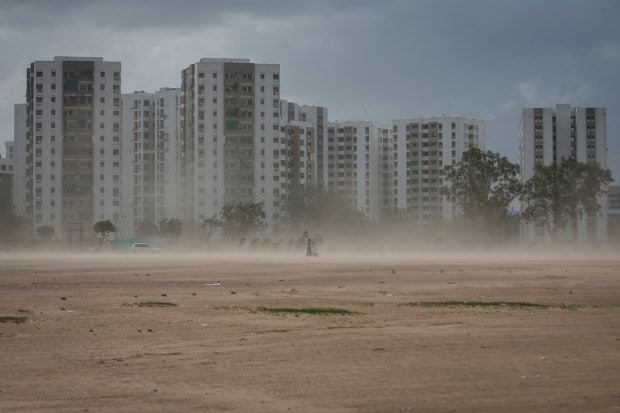 A couple rides a scooter amid dust due to strong wind, before the arrival of cyclonic storm Biparjoy, in Ahmedabad, India, June 15, 2023. (Reuters Photo)