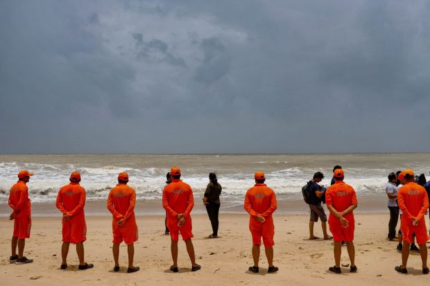 NDRF personnel at the Mandvi beach ahead of the landfall of Cyclone Biparjoy, in Kutch district. The government says that 15 teams of NDRF (National Disaster Response Force), 12 teams of SDRF (State Disaster Response Force), 115 teams of state road and building department, and 397 teams of the state electricity department have been deployed in different coastal districts.(Photo Credits: PTI)