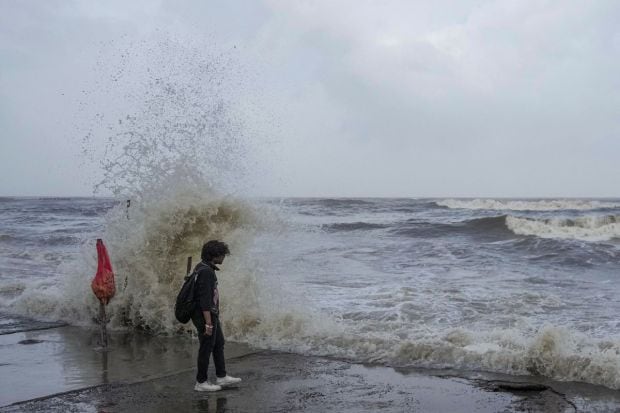 A man stands at Bandra beach while the high tidal waves lash the shore as the Biporjoy cyclone intensifies into a severe cyclonic storm, in Mumbai. (PTI Photo/Kunal Patil)