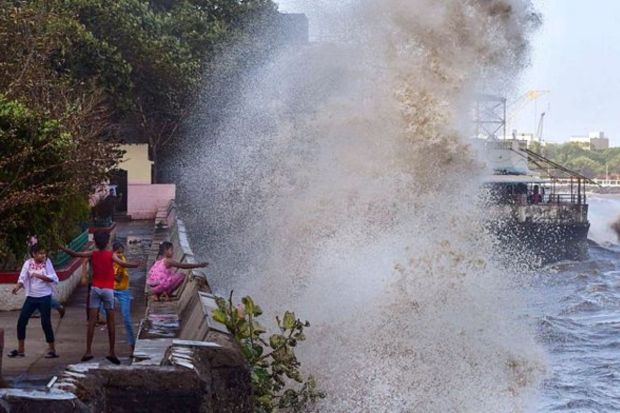 Children play as high tides crash at the sea front at Colaba, ahead of cyclone Biparjoy’s landfall in Kutch, in Mumbai. (PTI Photo)