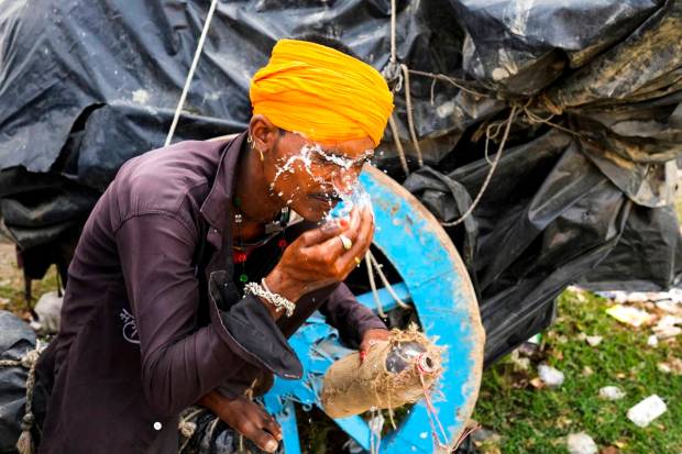 A man splashes water on his face to cool himself on a hot summer afternoon in Lalitpur district in northern Uttar Pradesh state, India. (AP Photo)