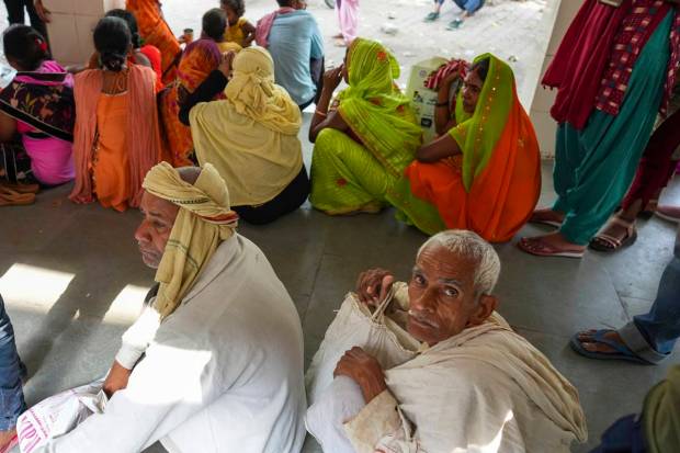 Elderly men wait in queue for patient registration at the district hospital in Ballia, Uttar Pradesh state, India. (AP Photo)