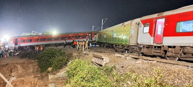 Wielding gas torches and electric cutters, rescuers worked through the night to pull out survivors and the dead from the mangled steel of three trains that derailed one on top of another. (PTI photo)